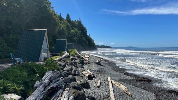 Ein Strand mit einer kleinen Konstruktion, möglicherweise eine Hütte, und einem Stuhl.