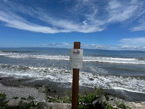 A sign indicating reserved parking at T-10, with a view of the ocean and waves in the background.