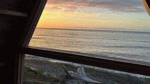 Blick auf das Meer durch ein Fenster mit Holzrahmen.