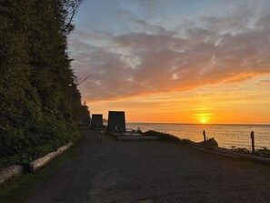 Uma trilha de cascalho leva a cabanas à beira-mar com vista para o pôr do sol.