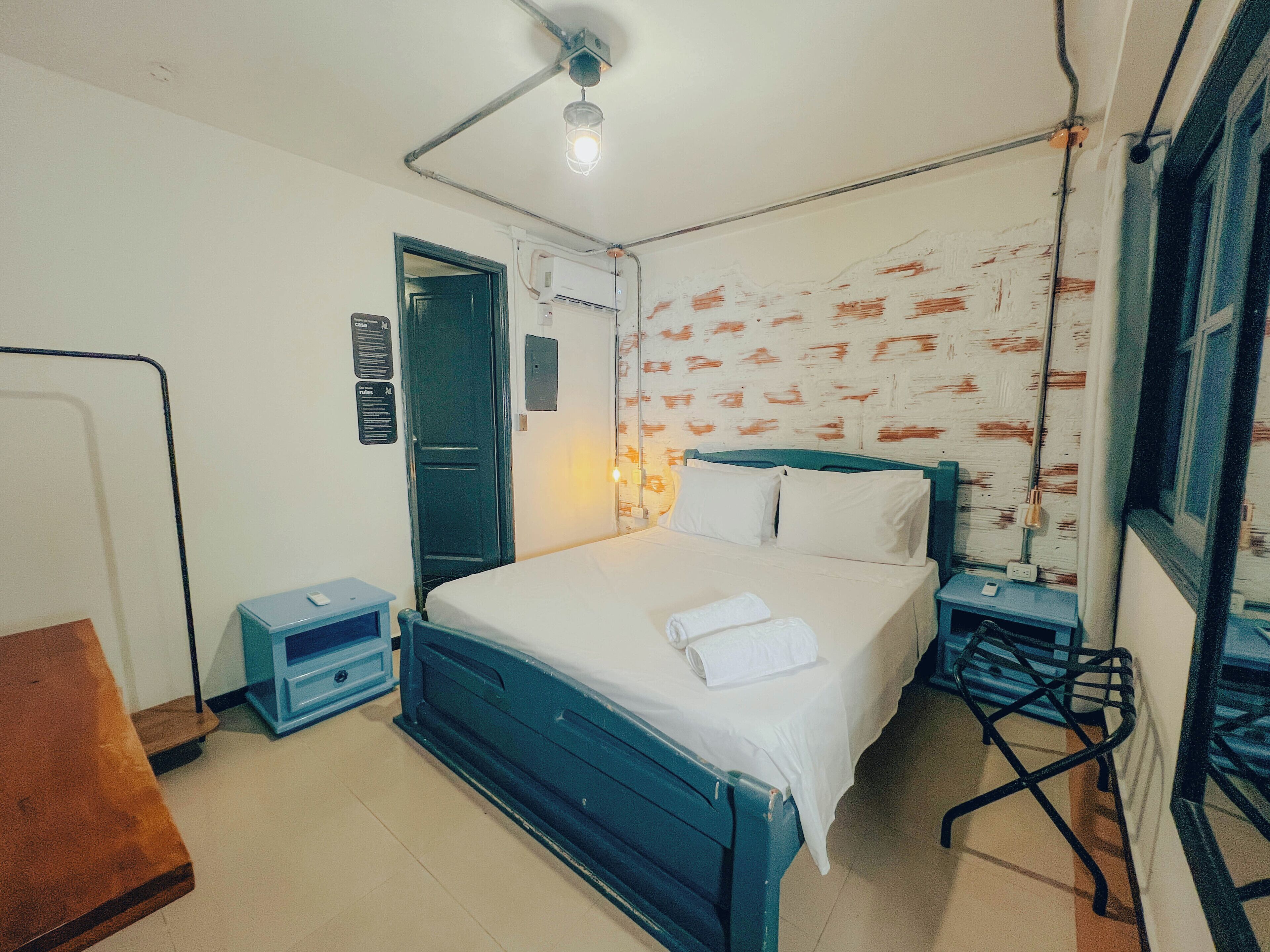 Une chambre à coucher comprenant un lit, des tables de chevet, une armoire, un bureau et une chaise.