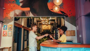 Zona de bar con mostrador, un mural en la pared y una araña.