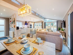Eine moderne Küche mit Essbereich, einer Couch und einem Fernseher.
