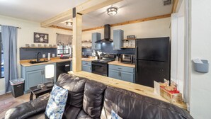 A compact kitchen with a stove, microwave, and cabinets.