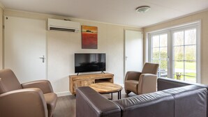 Een moderne woonkamer met een flatscreen televisie, leren banken en een houten salontafel.
