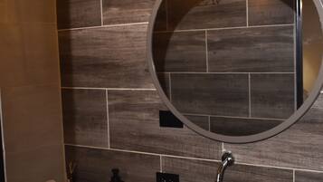 Chuveiro, toalhas de banho, sabonete, papel higiênico