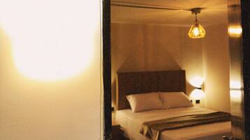 A hotel room with a bed, a ceiling fan, and a night light.