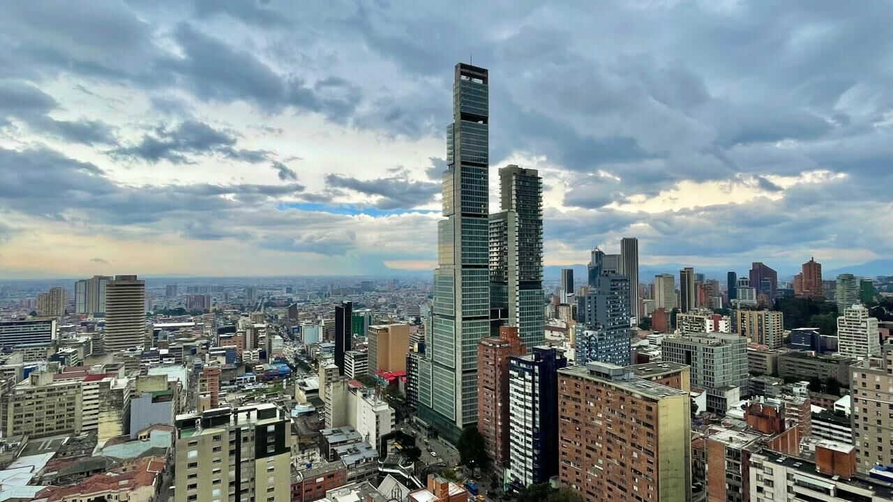 A cityscape with a prominent skyscraper featuring a unique design.