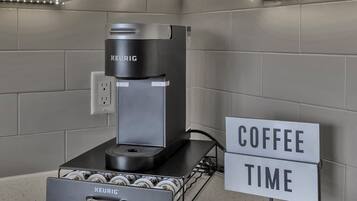 A modern kitchen with a Keurig coffee machine, a coffee pod holder, and a sign that reads "COFFEE TIME".