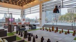 A rooftop lounge with outdoor seating, a large table, and decorative wooden sculptures. - Downtown High-Rise w/ City Views, Pool & Gym (Atlanta)