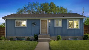 A two-story house with a front door, two windows on the first floor, and a small porch area. - Cozy home in Logan, close to USU (Logan)