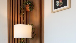 A cozy living room with a sofa, a lamp, and a framed picture on the wall. - Gîtes de France® - Au Salon d'Arthur (CRIEL SUR MER)