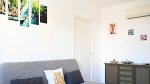 A room with a grey sofa, a cabinet with dishes, and a wall with pictures. - M417 - Marcelli, comfortable two-room apartment 100 meters from the sea (Marcelli)