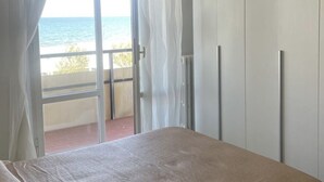 A bedroom with a view of the sea, a balcony, and a sliding door. - SE141 – Comfortable two-room apartment facing the sea (Senigallia)