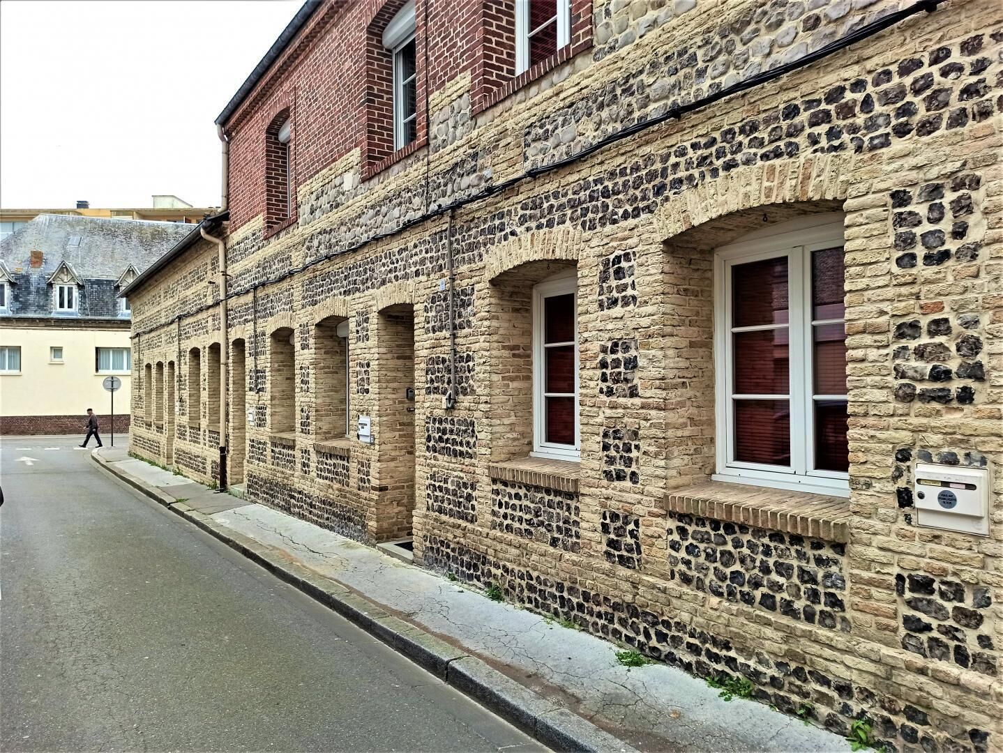 A historic stone building with arched windows and a brick facade.
