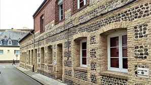 A historic stone building with arched windows and a brick facade. - Gîtes de France® - Les Fées Mer (DIEPPE)
