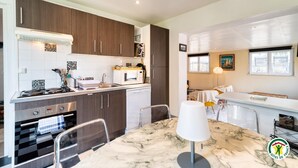 Une cuisine moderne avec des meubles en bois foncé, un plan de travail blanc et une table à manger en marbre.