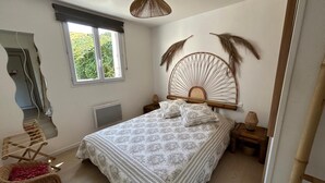 Une chambre à coucher comprenant un lit, une chaise, une fenêtre et un design original pour le panneau de tête de lit.