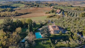A rural property with a swimming pool, stone house, and surrounding fields. - Villa Porri by MMega (Siena)