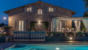 A stone building with a pool, outdoor seating, and a gate. - Villa Porri by MMega (Siena)