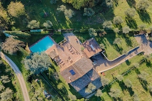 Vue aérienne d’une propriété dotée d’une piscine, d’un patio couvert et d’un jardin.