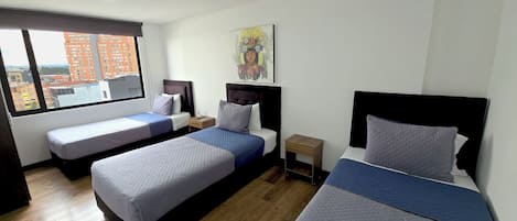 Standaard driepersoonskamer | Een kluis op de kamer, een laptopwerkplek, een strijkplank/strijkijzer