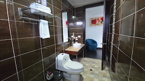 A modern bathroom with a toilet, sink, and towel rack. - Hotel City Center Corferias (Bogotá)