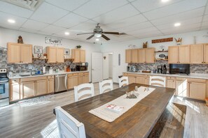 Een ruime keuken met houten kastjes, een groot eiland en moderne apparatuur.