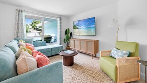 A living room with a sofa, armchair, and a round coffee table. - Costal Escape: Heated Pool~Tiki Bar~Hot Tub~Fire Pit~Acarde~Pool Table (Bradenton)