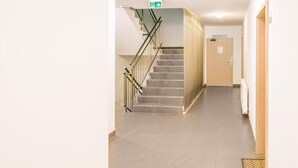 Un pasillo con una escalera, un letrero para un restaurante y una puerta.