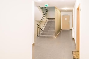 A hallway with a staircase, a sign for a restaurant, and a door.