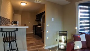 A modern kitchen with a bar area, wooden flooring, and a red leather sofa. - 4Bd 2Ba 7 Person Sleeper-  King Bed (Somerdale)