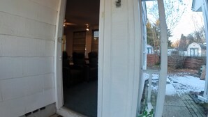 A garage entrance with a sliding door, a doormat, and a green lantern hanging above. - 4Bd 2Ba 7 Person Sleeper-  King Bed (Somerdale)