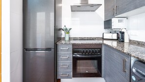 A modern kitchen with stainless steel appliances, a built-in oven, and a microwave. - Holiday Home 'Cozy Townhouse In Soneja' with Mountain View, Wi-Fi and Air Conditioning (Soneja)