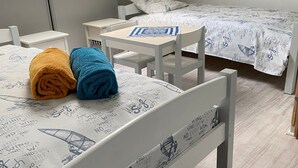 Een slaapkamer met twee bedden, een kleine tafel en een stoel.