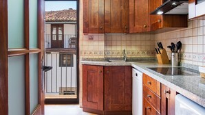 Une cuisine avec des armoires en bois, un plan de travail en granit et un dosseret carrelé.