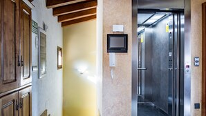 Un ascensor con panel de control, una pantalla pequeña y una puerta con el número 2.