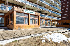 Un bâtiment doté d’une façade en bois et sur lequel on peut lire l’inscription « COSMOS ».