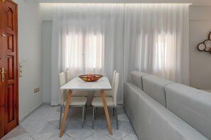 A dining area with a table, chairs, and a sofa.