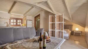 Um quarto acolhedor no estilo loft, com teto alto, sofá, mesa de jantar com garrafas de vinho e cama com cabeceira.