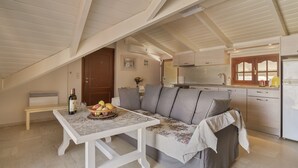 Um espaço de estar acolhedor no estilo loft, com mesa de jantar, sofá e cozinha compacta.