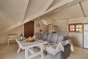 Un espace de vie chaleureux de style loft, comprenant une table à manger, un canapé et un coin cuisine.