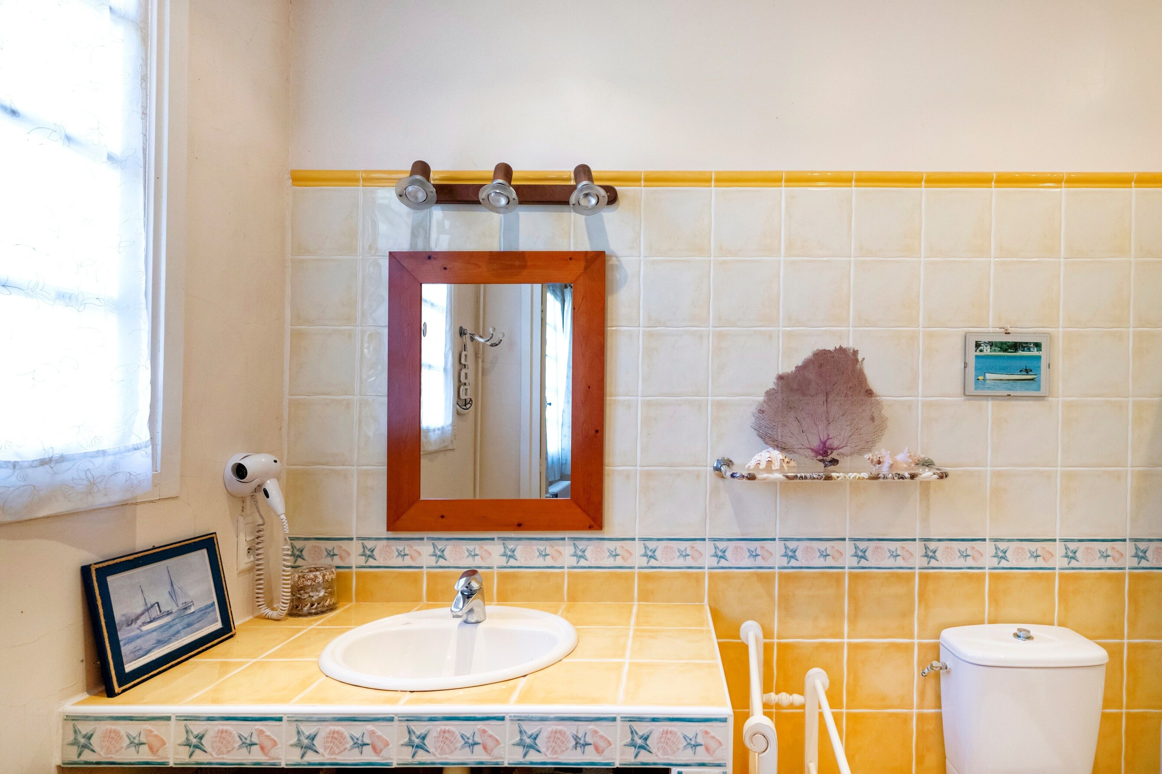 A bathroom with a sink, mirror, towel rack, and toilet.