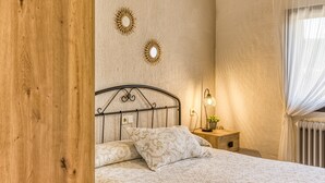 A bedroom with a bed, bedside table, lamp, and decorative wall sconces. - Country House 'Can Planas 1' with Shared Pool, Wi-Fi and Air Conditioning (Fonolleres)