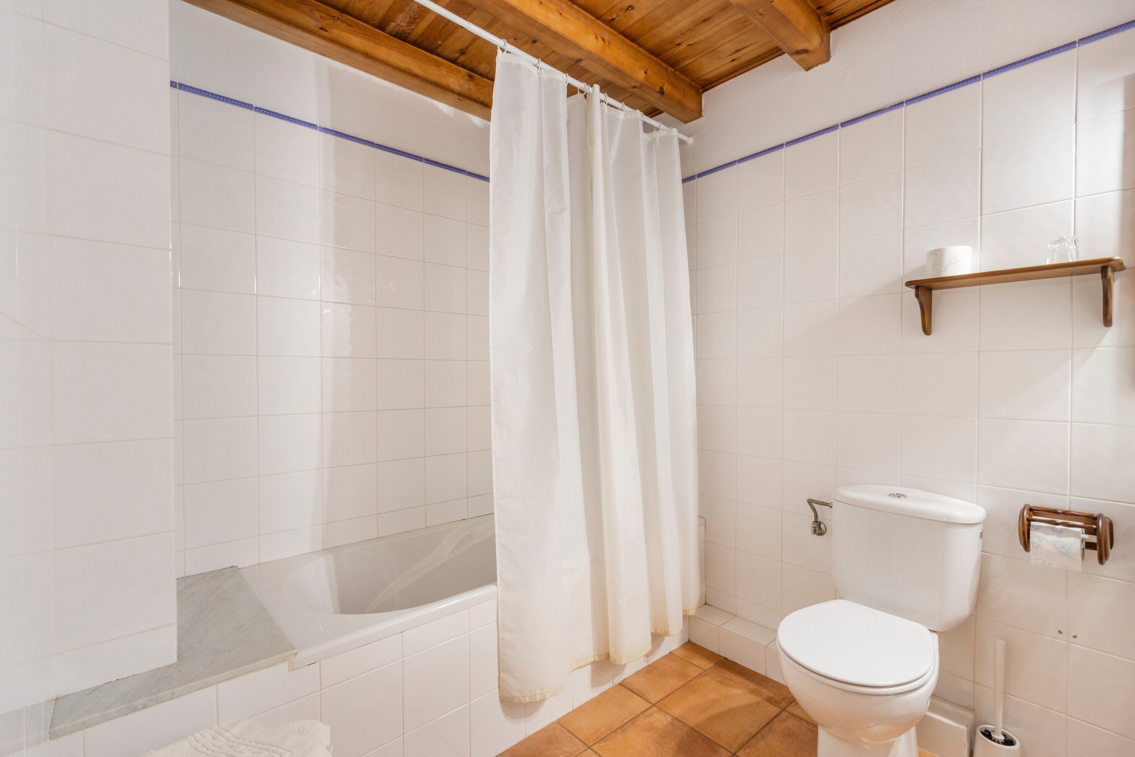 Un baño con bañera, inodoro y cortina de ducha.