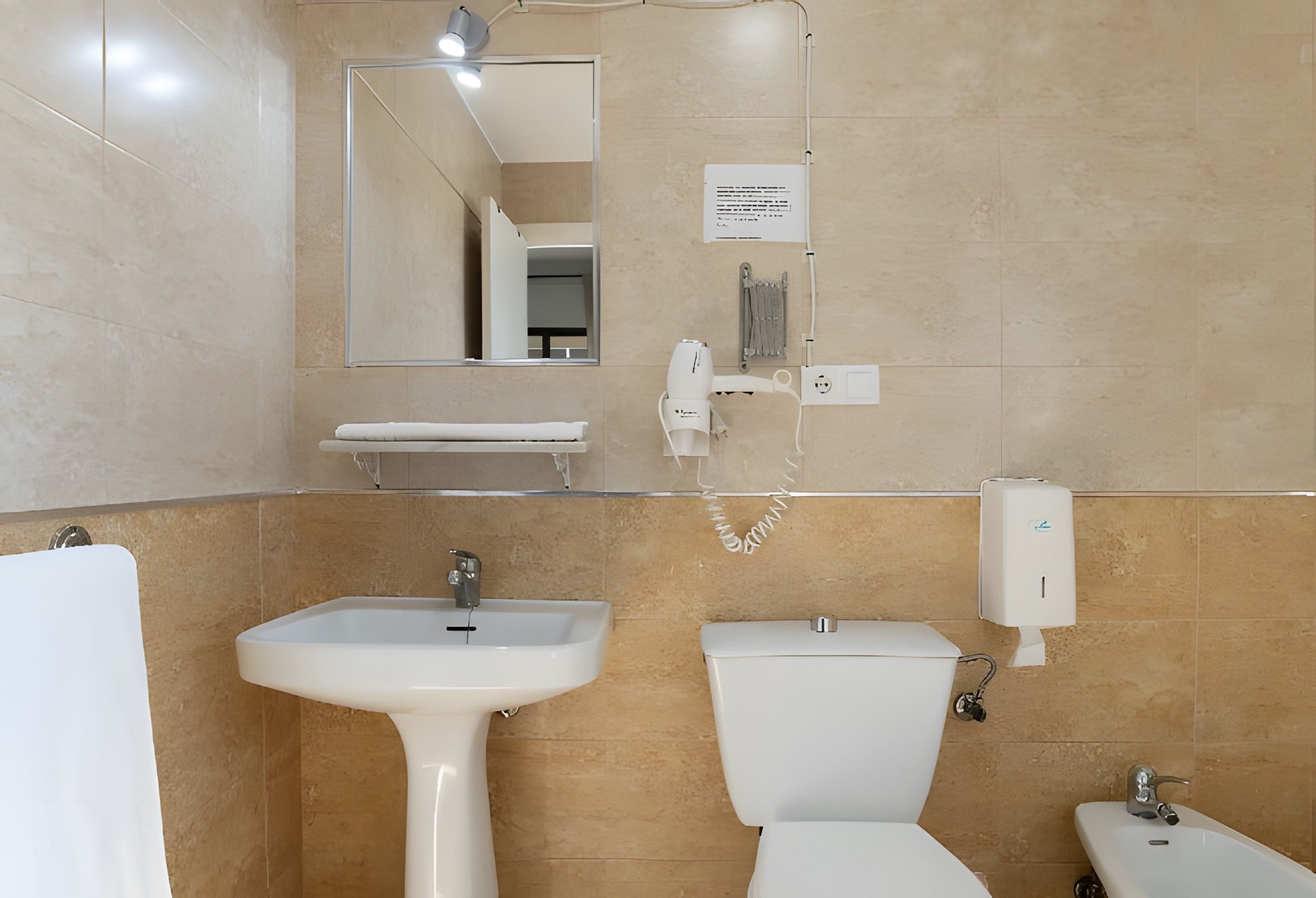 Une salle de bain avec un lavabo, des toilettes et un miroir.