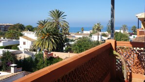 A coastal residential area with white buildings, palm trees, and a clear view of the sea. - Apartment 'Gaby' with Sea Views, Wi-Fi and Air Conditioning (Denia)