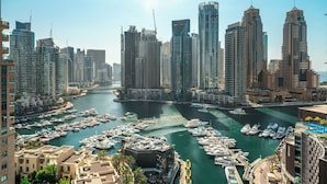 A marina with numerous boats docked, surrounded by high-rise buildings. - Silkhaus Al Mass (Dubai)