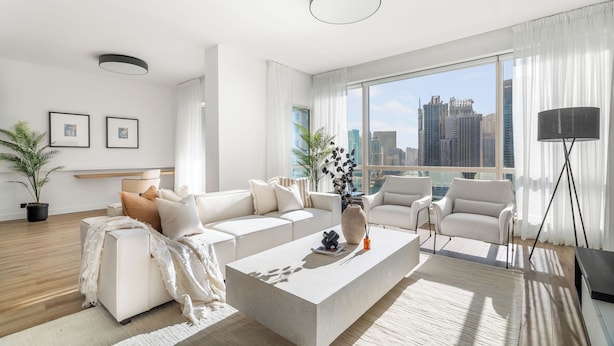 A modern living room with a large window, white furniture, and a city view. - Silkhaus Al Mass (Dubai)