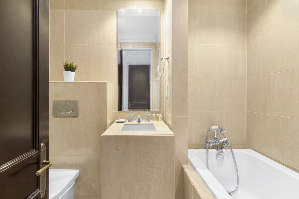 Een moderne badkamer met een badkuip, een wastafel en een spiegel.